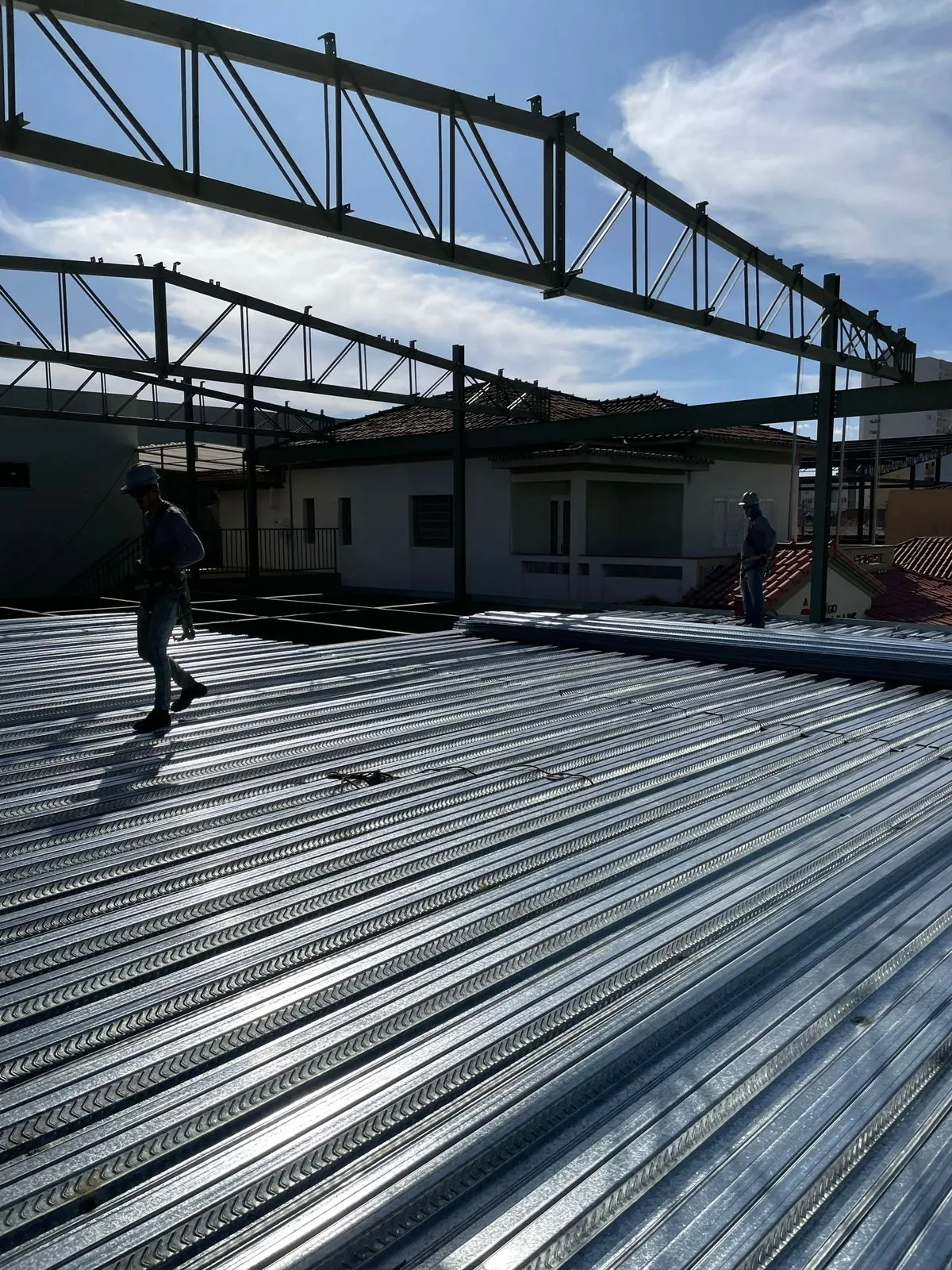 Montagem de laje steel deck com equipe usando cinto de segurança NR-35